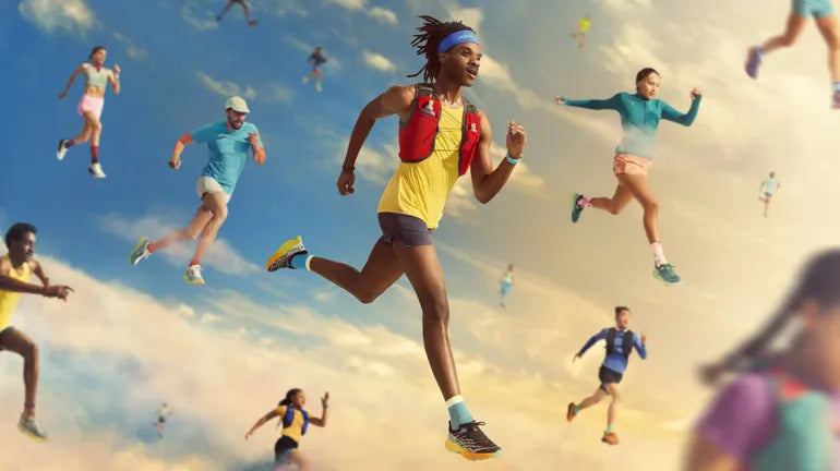Diverse runners in colorful athletic gear and hydration vests sprinting against a bright, cloudy sky.