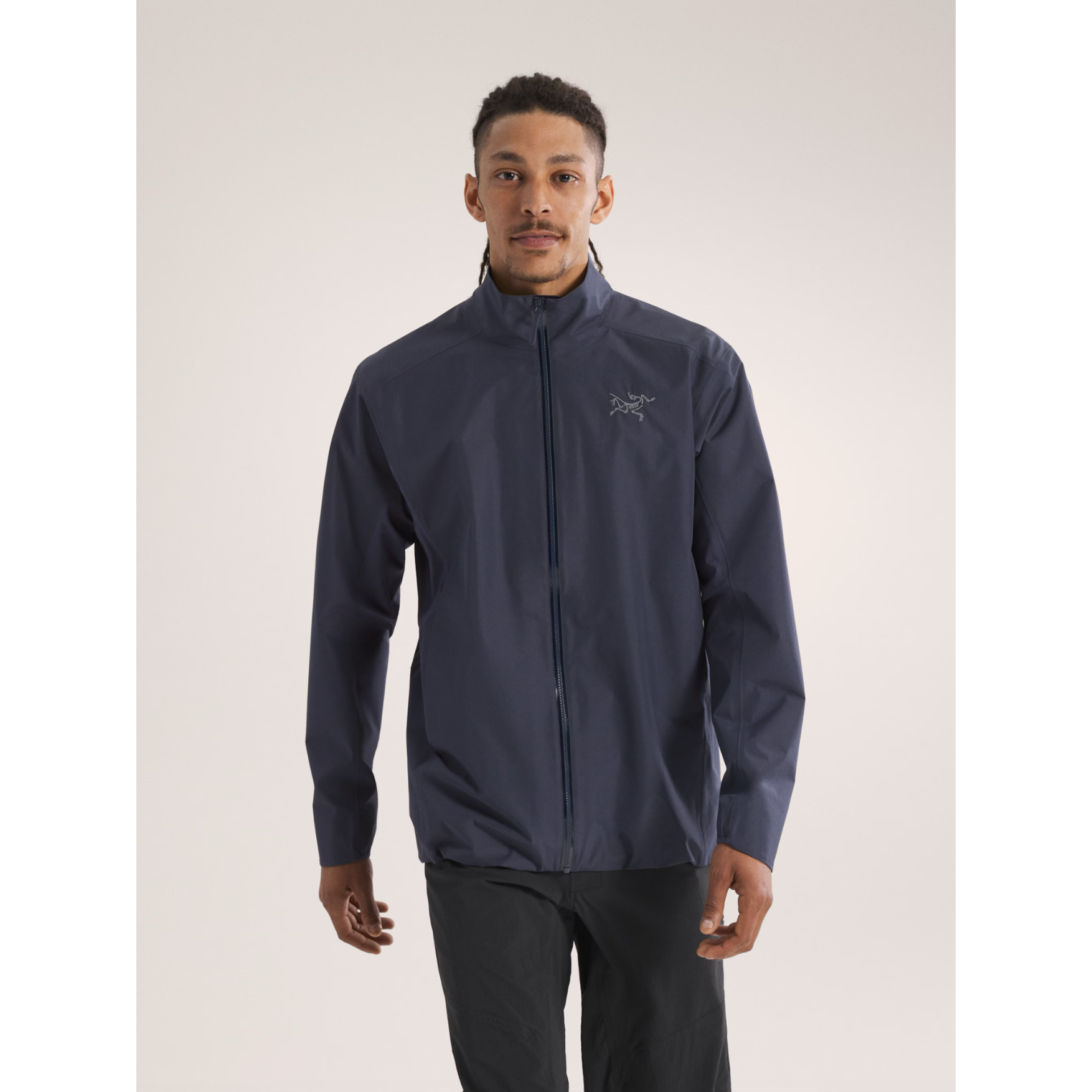 Man wearing a dark navy Arc'teryx zip-up technical shell jacket with a minimalist outdoor design.