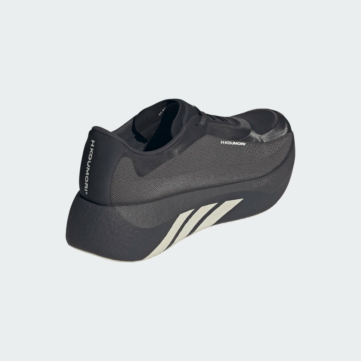 Black Adidas Hyperboost Edge Hermanos Koumori running shoe with a textured mesh upper and white side stripes on a thick sole.