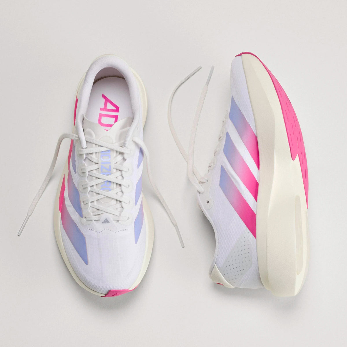 Adidas Women's Adizero EVO SL running shoes in white with pink and blue gradient stripes and a thick, lightweight foam sole.
