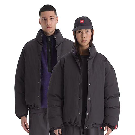Two models wearing black The North Face Red Box down jackets with snap-button closures and wind-resistant fabric.